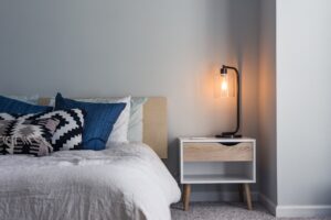 Cama con topper viscoelástico y ropa de cama blanca en un dormitorio acogedor con luz natural
